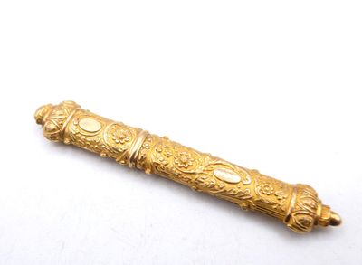 a gold object on a white surface with a white background