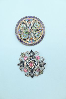three brooches of different shapes and sizes on a white surface