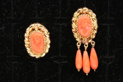 two pairs of coral and gold earrings on a black velvet surface