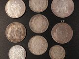 a bunch of silver coins sitting on top of a black surface