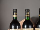 three bottles of wine in a wooden box on a table