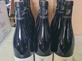 quatre bouteilles de vin sont posées sur une table devant un carton