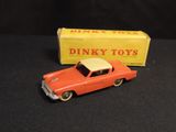 a toy car that is sitting next to a box of dinky toys