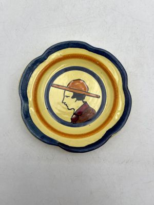 une assiette sur laquelle est représenté un homme portant un chapeau