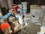 many buckets of paint sitting on a table next to a chair