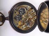 a close up of a pocket watch on a white surface