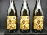trois bouteilles de vin posées sur un bloc de bois