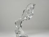 a glass sculpture of a horse that is standing on it ' s hind legs
