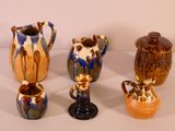 four different types of vases sitting on a table with a white background