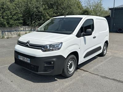 Une camionnette Citroën garée sur un parking, avec des arbres en arrière-plan
