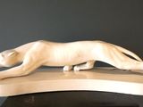 statue d'un chat posée sur un socle, sur une surface noire