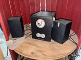 three speakers sitting on top of a table in a room