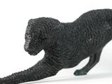 statue of a black dog on a white surface with a white background