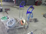un chariot rempli d'outils posé à même le sol dans un garage