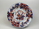 a blue and red plate with a bird and flowers on it