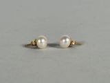 a pair of pearl earrings on a white surface