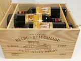 bottles of wine in a wooden box on a white surface