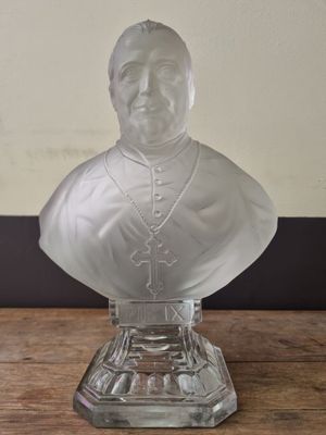 a close up of a glass bust of a man on a table
