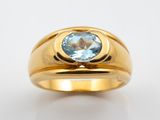 une image d'une bague en or avec une pierre en topaze bleue