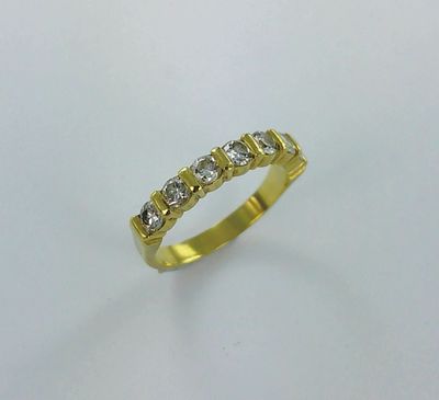 une bague en or jaune sertie de cinq diamants sur fond blanc