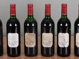 six bottles of wine are lined up on a wooden table