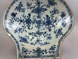 two blue and white plates with floral designs on them on a table