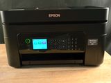 a black printer sitting on top of a wooden table