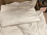 une boîte en carton posée par terre, contenant une chemise blanche