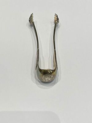 a silver spoon on a white surface with a spoon sticking out of it
