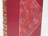 a red book with gold trim and a red cover
