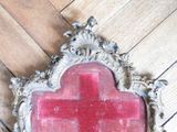 a red cross on a mirror on a wooden floor