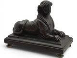 statue d'un lion posée sur un socle en bois, sur fond blanc