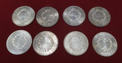 six silver coins are arranged in a row on a red surface