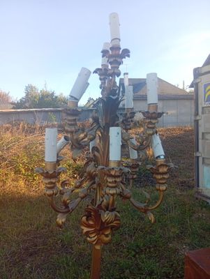 un lustre doré posé dehors, dans l'herbe