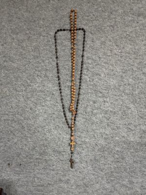 collier orné de perles et d'une croix suspendue à son cou