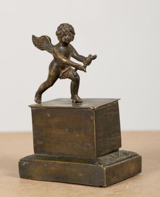 une statue en bronze représentant un Cupidon tenant une raquette de tennis