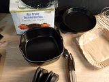 several pans and utensils on a table with a box of baking utensils