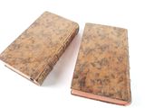 pair of old leather bound books on a white surface
