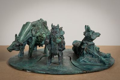 a bronze sculpture of a man riding a horse and a cow