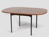 an oval dining table with black legs and a walnut top