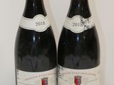 deux bouteilles de vin rouge posées sur une table blanche