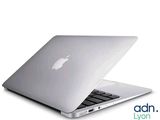 un ordinateur portable Apple blanc posé sur une table blanche