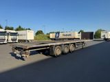three semi trucks that are parked on the side of the road