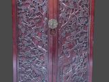 une image d'une armoire en bois avec des sculptures sur les portes