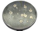a small silver pill case with flowers on it