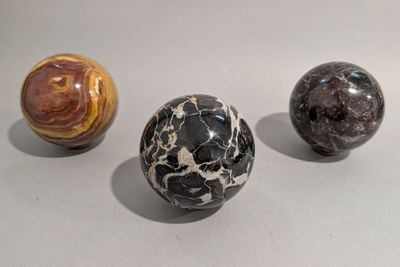 trois billes de marbre posées sur une surface blanche