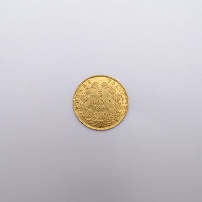 a close up of a gold coin on a white surface