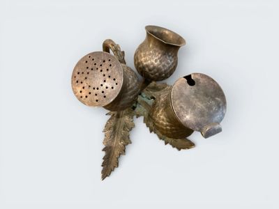 three metal objects that are sitting on a white surface