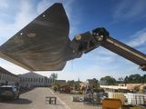 a large excavator that is lifting a large piece of metal