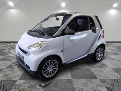 une petite voiture blanche garée dans une pièce